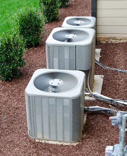 Three AC system units lined up outside a building.