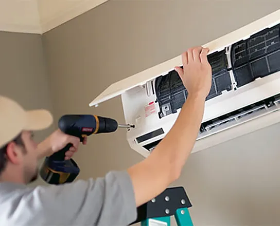 Technician performing professional refrigerant leak repair on a wall-mounted air conditioner.